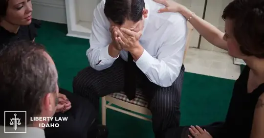 man crying and being comforted